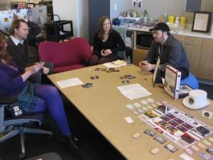 Players enjoy a game of CDS Mess next to Corporate America at the financial irresponsibility board game corner.